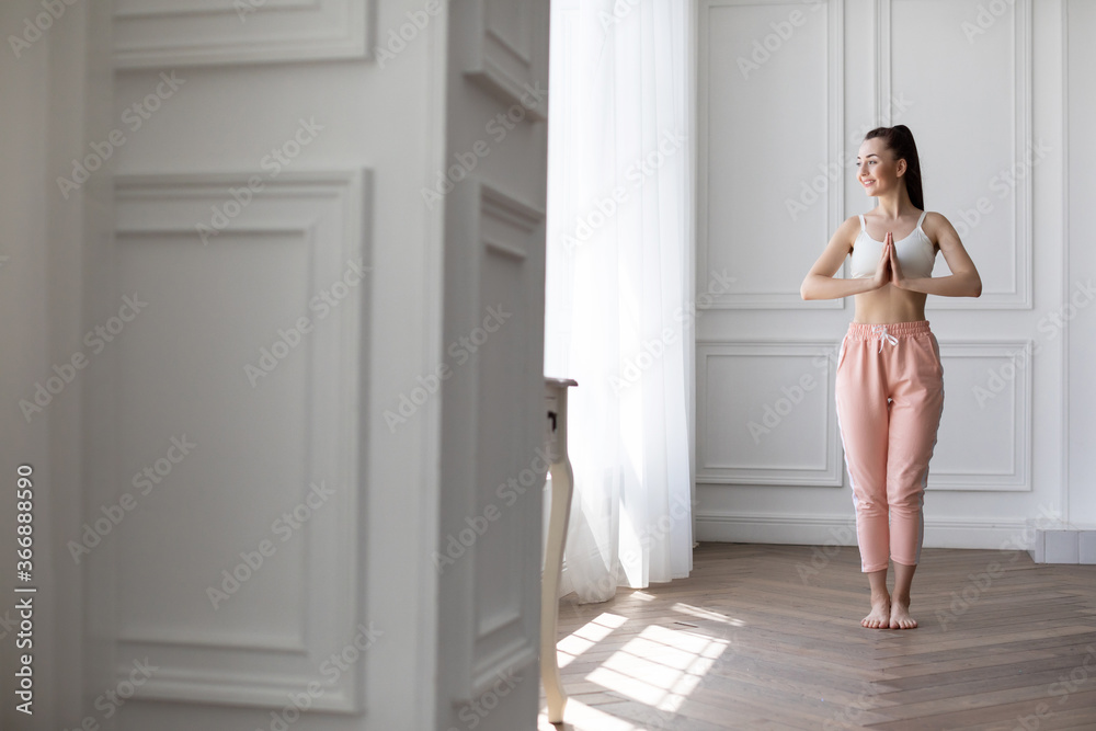 Young happy woman doing relaxing exercises at home in the morning. Young happy woman doing relaxing exercises at home in the morning.