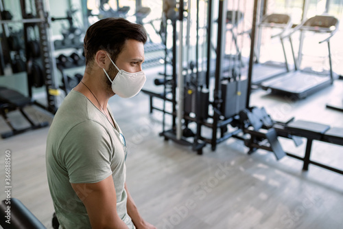 Pensive athlete with protective face mask at health club.
