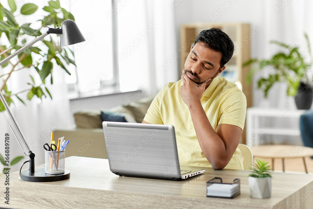 technology, remote job and lifestyle concept - indian man with laptop computer thinking at home office technology, remote job and lifestyle concept - indian man with laptop computer thinking at home office