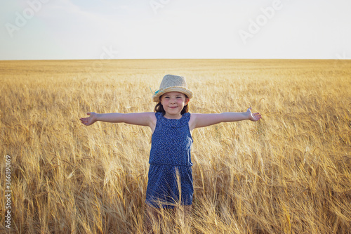  An emotional portrait of a little girl in a wheat field. High quality photo