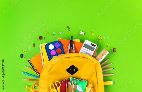 School backpack isolated on green background.