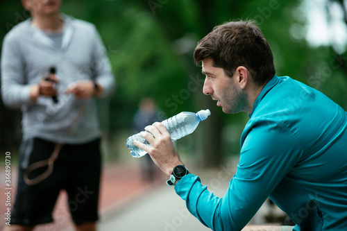 Thirsty athlete. Man having water after a workout. 