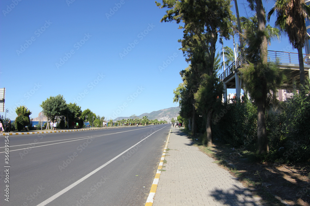 Alanya, TURKEY - August 10, 2013: Travel to Turkey. Clear blue sky. Alanya city, clean streets, houses and roads. Passenger transport, cars. Alanya, TURKEY - August 10, 2013: Travel to Turkey. Clear blue sky. Alanya city, clean streets, houses and roads. Passenger transport, cars.