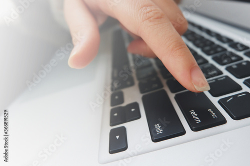 close up image of a person clicking enter on the keyboard.