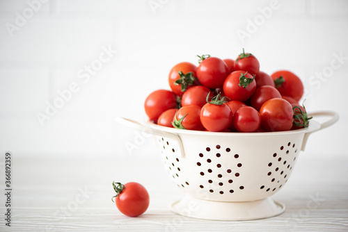 small red tomatoes in a colander