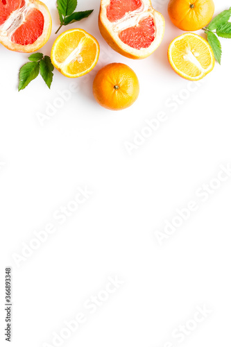 Oranges and grapefruits with leaves on table top view copy space