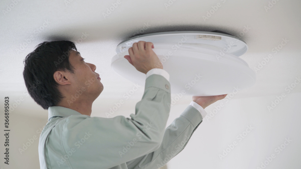 照明器具を取り付ける男性	
