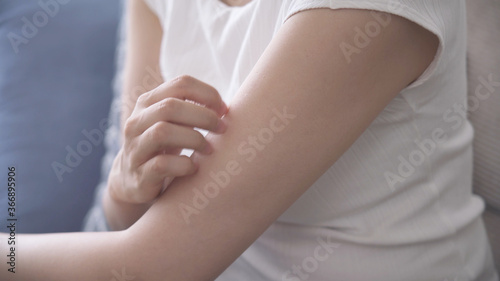 腕を掻いている若い女性 