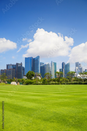 Landscape with Singapore financial district. Empty green lawn with modern architecture at background. Travel, nature, background, landmark, tourist destination concept © kite_rin