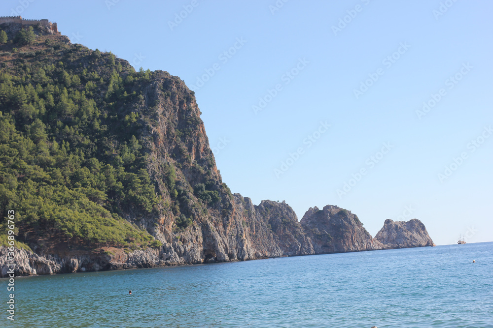 Alanya, TURKEY - August 10, 2013: Travel to Turkey. The pier. Clear blue sky. The waves of the Mediterranean Sea. Water surface. Coast.