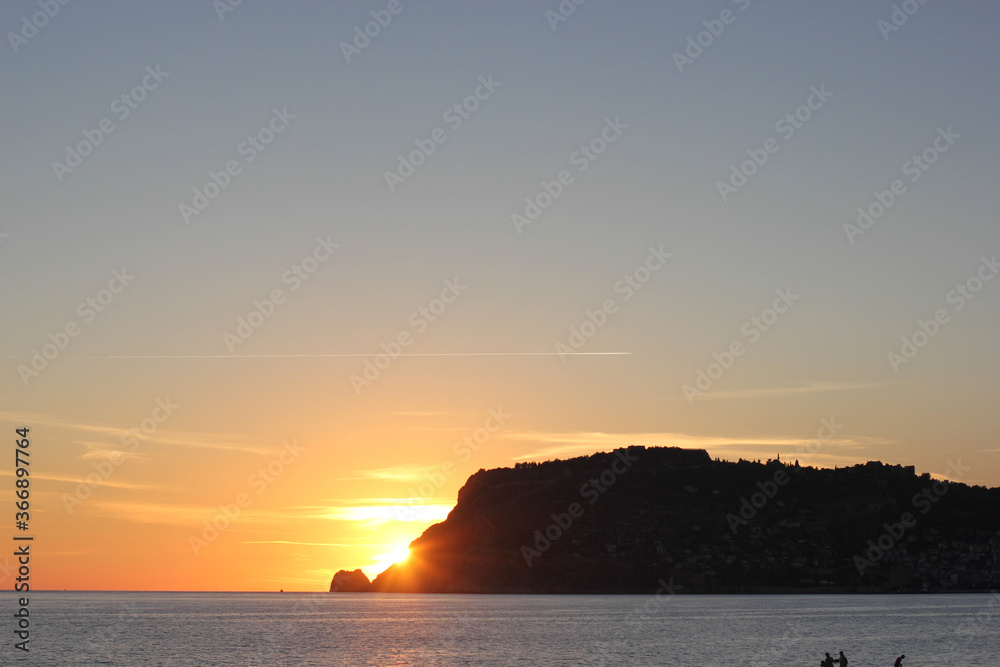 Alanya, TURKEY - August 10, 2013: Travel to Turkey. Beaches on the Mediterranean coast. The sun is leaving the horizon. Sunset