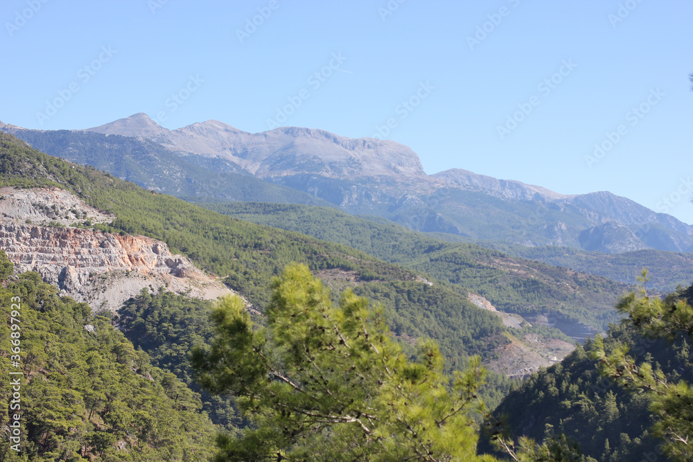 Alanya, TURKEY - August 10, 2013: Travel to Turkey. Helene Hills. Mountains in the background in the distance. Rocks, wildlife of Turkey. Forest and clear blue sky.