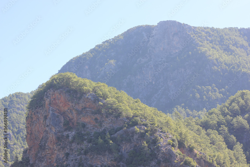 Alanya, TURKEY - August 10, 2013: Travel to Turkey. Helene Hills. Mountains in the background in the distance. Rocks, wildlife of Turkey. Forest and clear blue sky. Alanya, TURKEY - August 10, 2013: Travel to Turkey. Helene Hills. Mountains in the background in the distance. Rocks, wildlife of Turkey. Forest and clear blue sky.