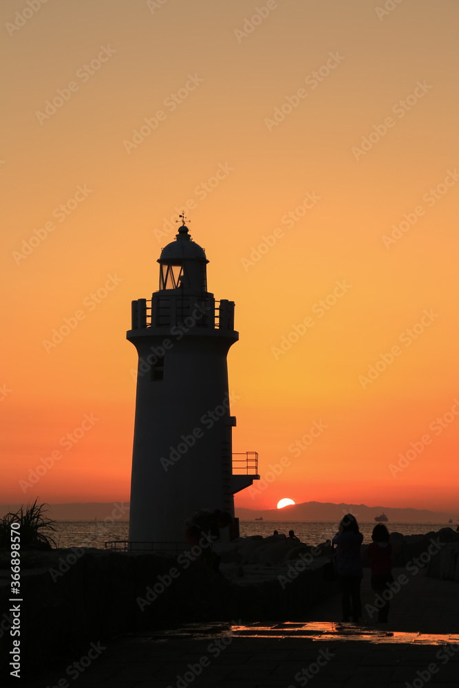 夕日に染まる伊良湖岬灯台と観光客
