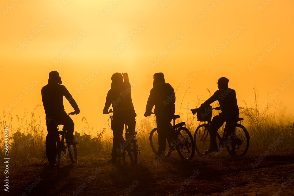 Silhouette group of people cyclist looking view sea fog in the morning