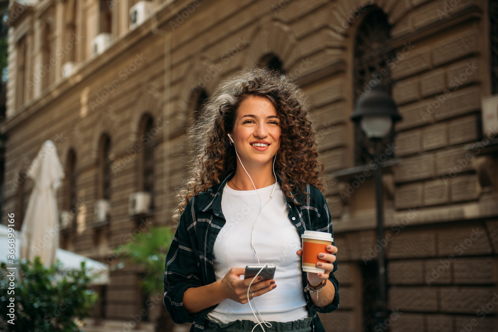Portrait of beautiful curly hair woman with coffee to go