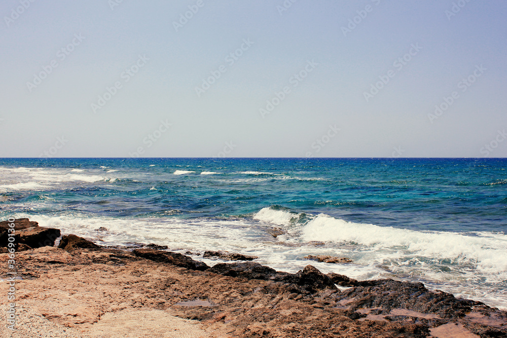 Background of blue sea. Rocky coast of the sea. Mediterranean sea in Cyprus. Nature background. Blue lagoon. Sea shore with summer Sunny day. Background of blue sea. Rocky coast of the sea. Mediterranean sea in Cyprus. Nature background. Blue lagoon. Sea shore with summer Sunny day.