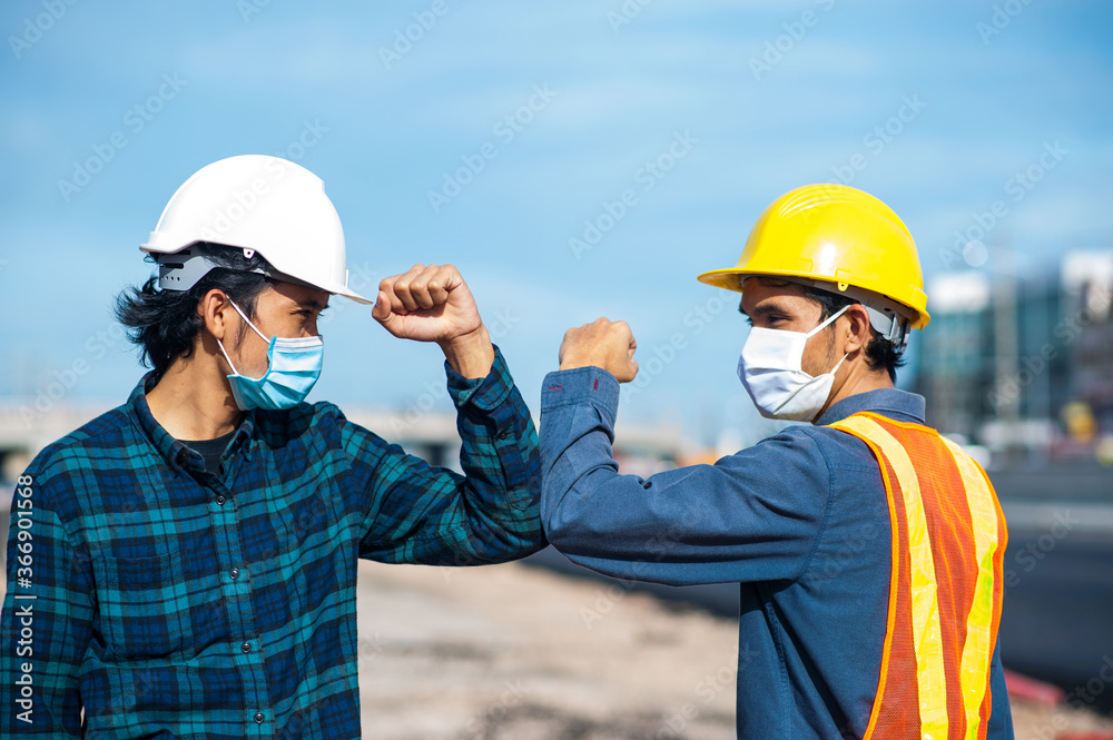 Asian man Engineer shake hand not touch new normal style,Two Engineer a wearing face mask protect corona virus PM2.5 on site construction Asian man Engineer shake hand not touch new normal style,Two Engineer a wearing face mask protect corona virus PM2.5 on site construction
