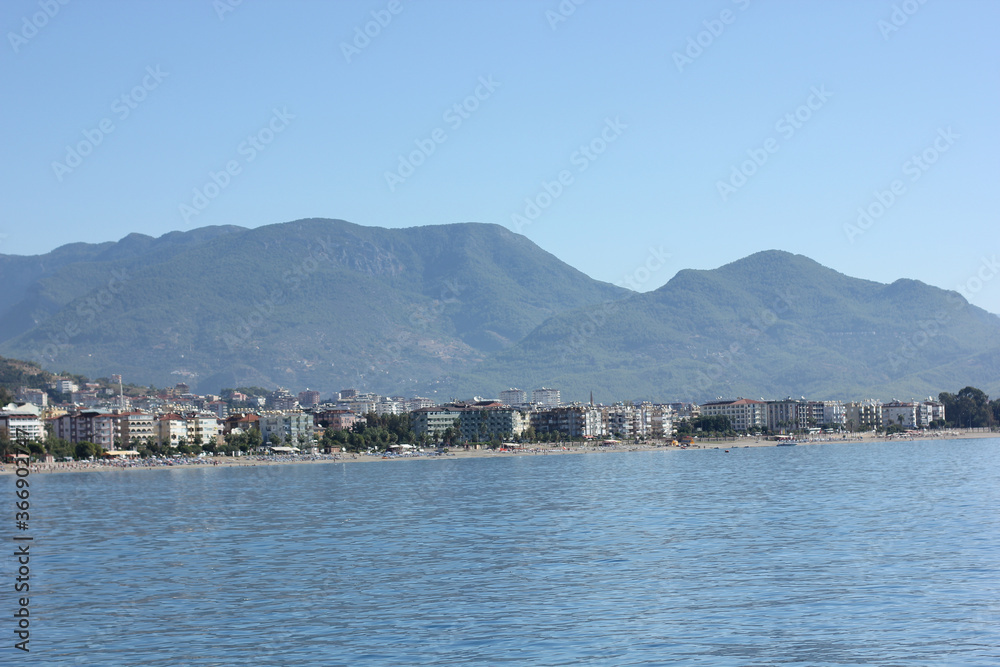 Alanya, TURKEY - August 10, 2013: Travel to Turkey. The waves of the Mediterranean Sea. Water surface. Port. Ships on the water. Boats at sea. Yachts and other water transport. Mountains in the backgr