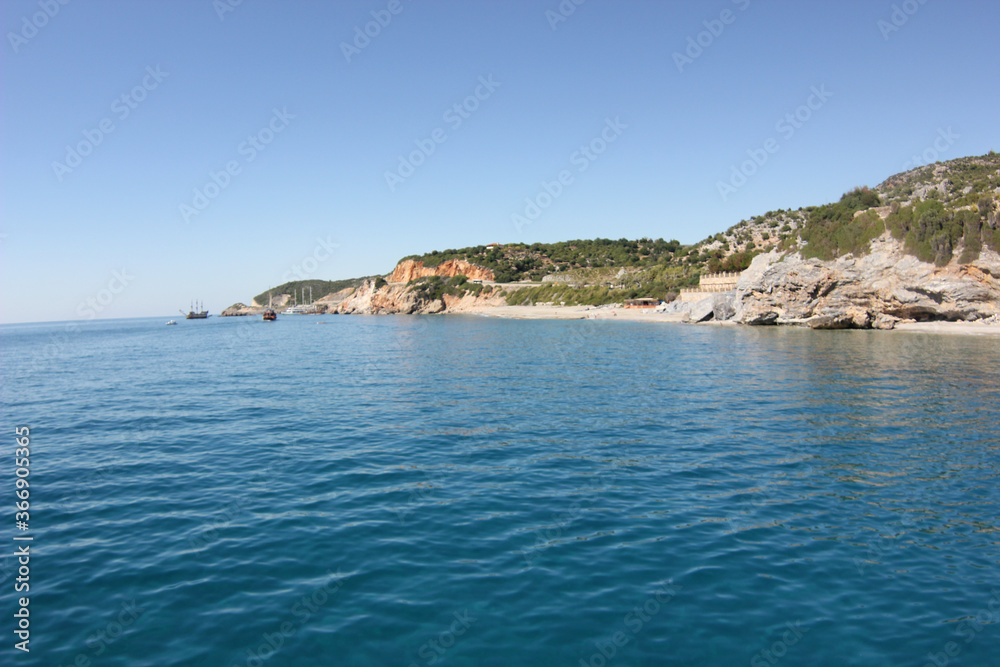 Fototapeta premium Alanya, TURKEY - August 10, 2013: Travel to Turkey. The waves of the Mediterranean Sea. Water surface. Mountains and hills on the coast of Turkey. Green hills.