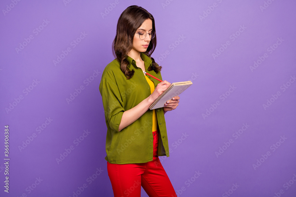 Portrait of focused smart girl high school student study remote write copybook lecture report wear pants isolated over purple color background Portrait of focused smart girl high school student study remote write copybook lecture report wear pants isolated over purple color background