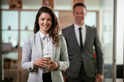 Portrait of beautiful businesswoman in office. Young businesswoman drinking coffee. 