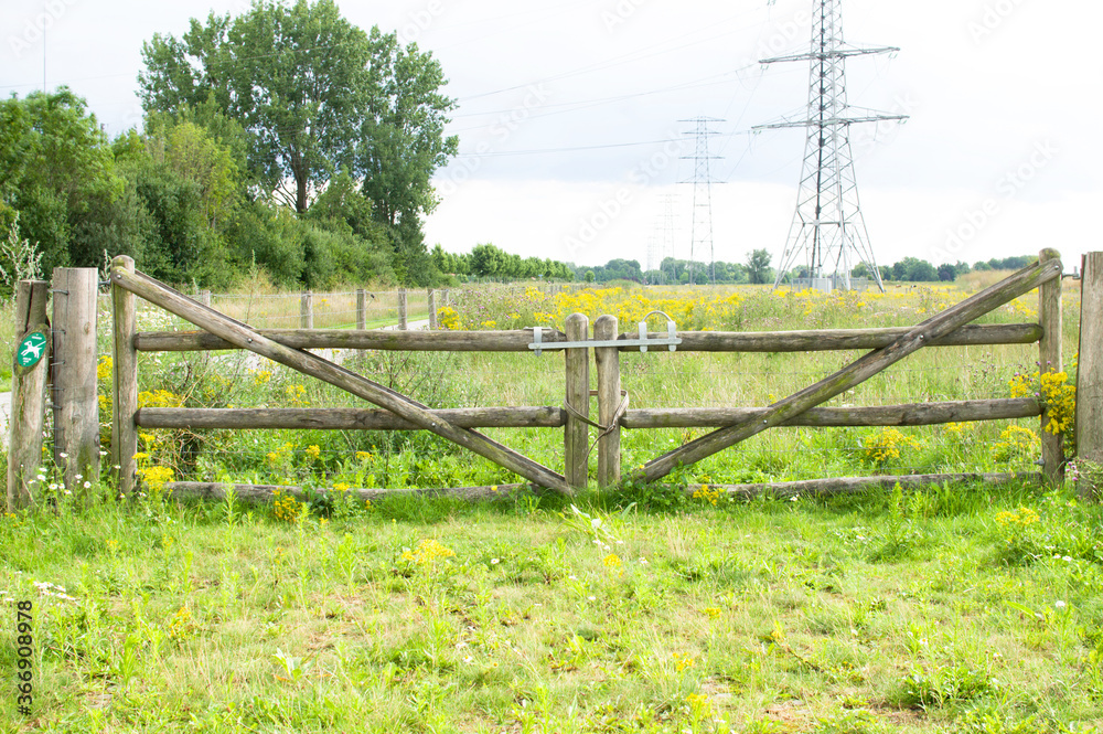 Fototapeta premium Old wooden closed gate that gives access to a meadow