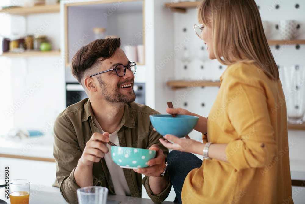 Happy couple eating breakfast at home. Husband and wife enjoying in the morning. Happy couple eating breakfast at home. Husband and wife enjoying in the morning.