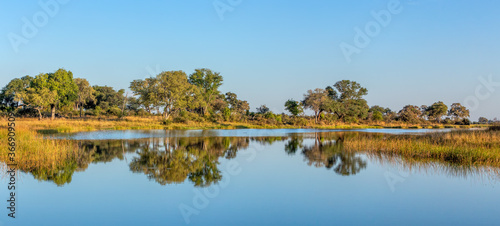 Typical beautiful african landscape, wild river in national park Bwabwata on Caprivi Strip with nice reflection in water. Namibia africa wilderness. photo