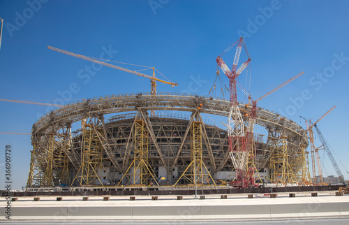 construction side of a football stadium with cranes and scaffoldings 