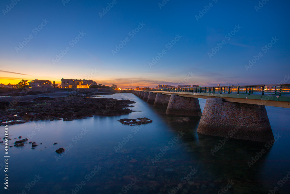 Obraz premium Entrance of Les Sables D'Olonne harbour taken from La Chaume, with it piers and lighthouse at sunset, Vendee, France