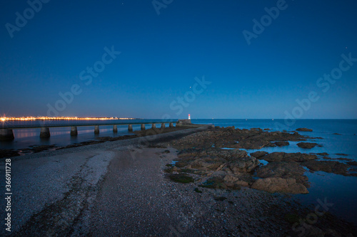 Entrance of Les Sables D Olonne harbour taken from La Chaume  with it piers and lighthouse at sunset  Vendee  France