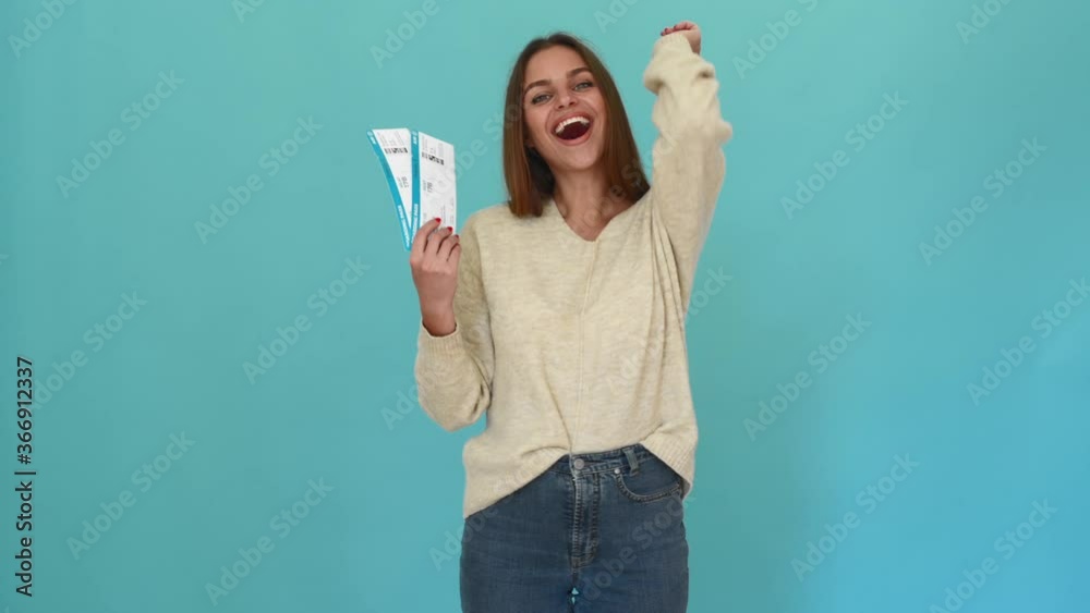 excited happy woman with airplane tickets in hand smiling isolated on blue background excited happy woman with airplane tickets in hand smiling isolated on blue background