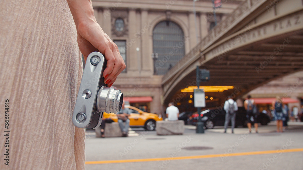 Young girl with a retro camera at the railway station in New York Young girl with a retro camera at the railway station in New York