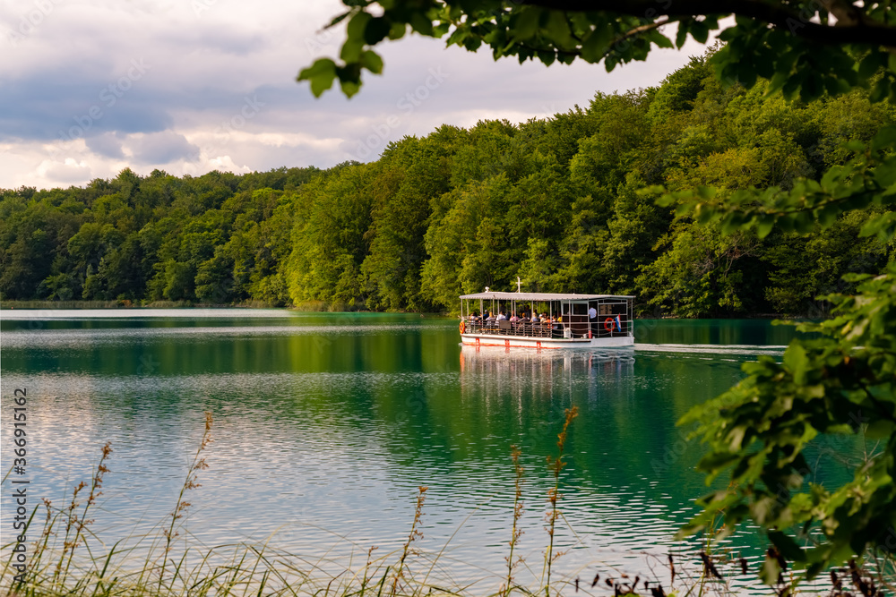 Fototapeta premium Plitvicer Seen Kroatien Boot Fähre Touristen Nationalpark Naturschutzgebiet Paradies Attraktion Sehenswürdigkeit Urwald Wasser See Spiegelung türkis Welterbe Nacionalni park Plitvička