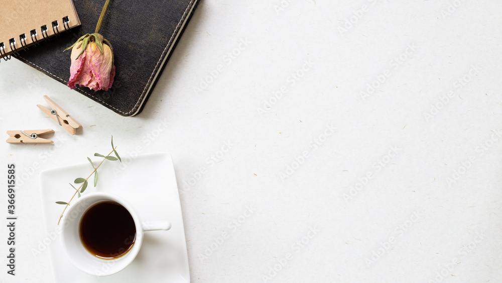 Notebook and black coffee with dry flower on white background. flat lay, top view, copy space. Work and study place. Notebook and black coffee with dry flower on white background. flat lay, top view, copy space. Work and study place.