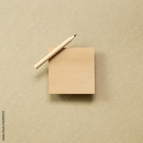 Memo note pad with wooden pencil on brown kraft paper background. top view, copy space © Sanga