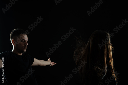 Creating new hair look. Young barber, hairdresser stands with raised hands near his client girl model