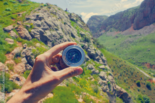 Compass in hand on a background of nature