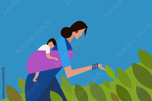 Woman carrying a baby on her back white working in a farm