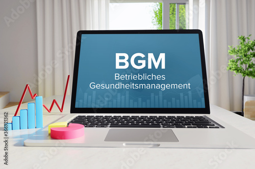 BGM (Betriebliches Gesundheitsmanagement). Business/Statistik. Laptop Computer mit Diagramm auf Schreibtisch im Büro. Text auf dem Monitor. Finanzen, Wirtschaft, Analyse photo