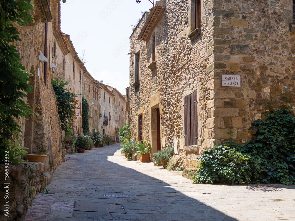 Medieval architecture street in Monells village in Catalonia, Spain (Inscription on the street plate: Street of Arches)