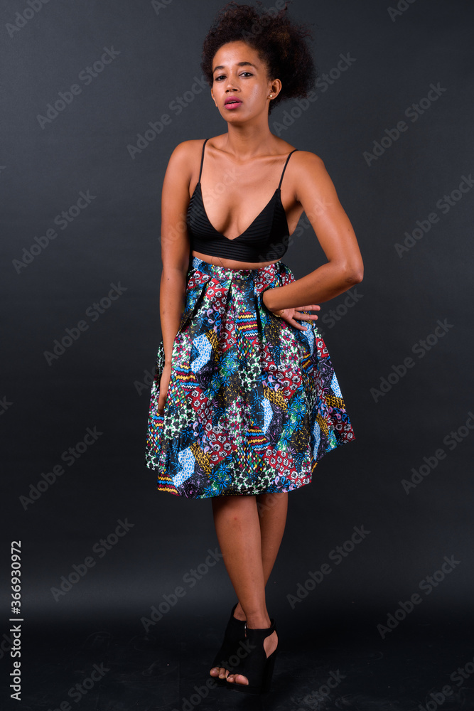 Young beautiful African woman with Afro hair against black background Young beautiful African woman with Afro hair against black background