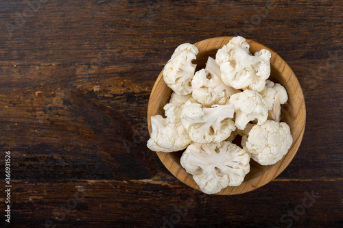 Cauliflower in a wooden bowl on a wooden background. Harvesting.