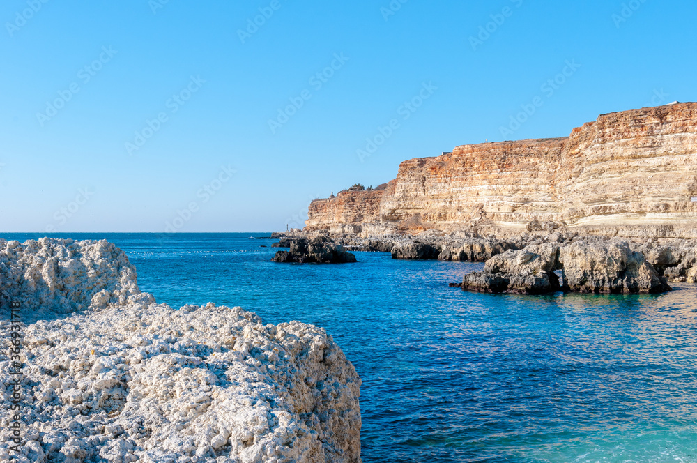 Fototapeta premium Beautiful black sea landscapes on South of Russia. Orange mountains an many birds on beach rocks