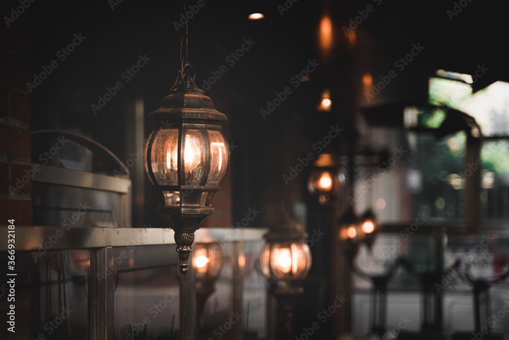 Lit worn out retro lanterns against a blurry background