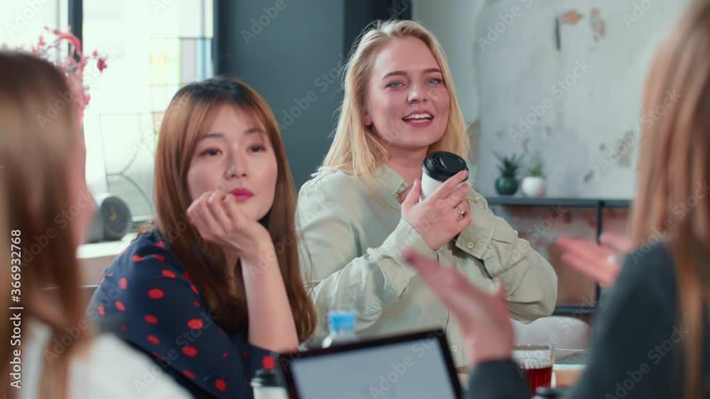 Women at modern multiethnic office workplace. Attractive happy young 20s Caucasian business woman speaks at meeting. Women at modern multiethnic office workplace. Attractive happy young 20s Caucasian business woman speaks at meeting.