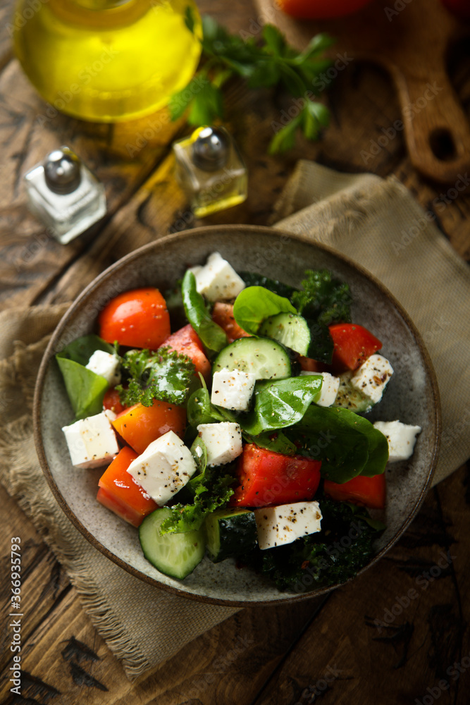 Traditional Greek salad with fresh spinach