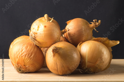 Onions on a wooden chopping board.