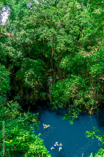 Yokdzonoto, Yucatan / Mexico - August 2018: People swiming at Yokdzonot Cenote photo